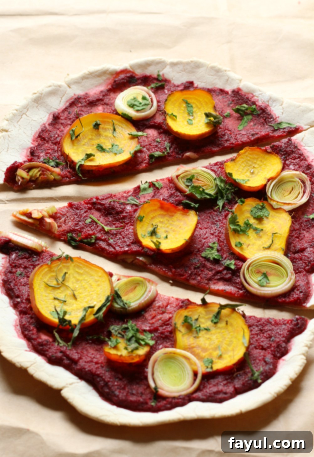 Beet & Leek Cassava Crust Pizza, featuring a vibrant, healthy crust topped with colorful vegetables.