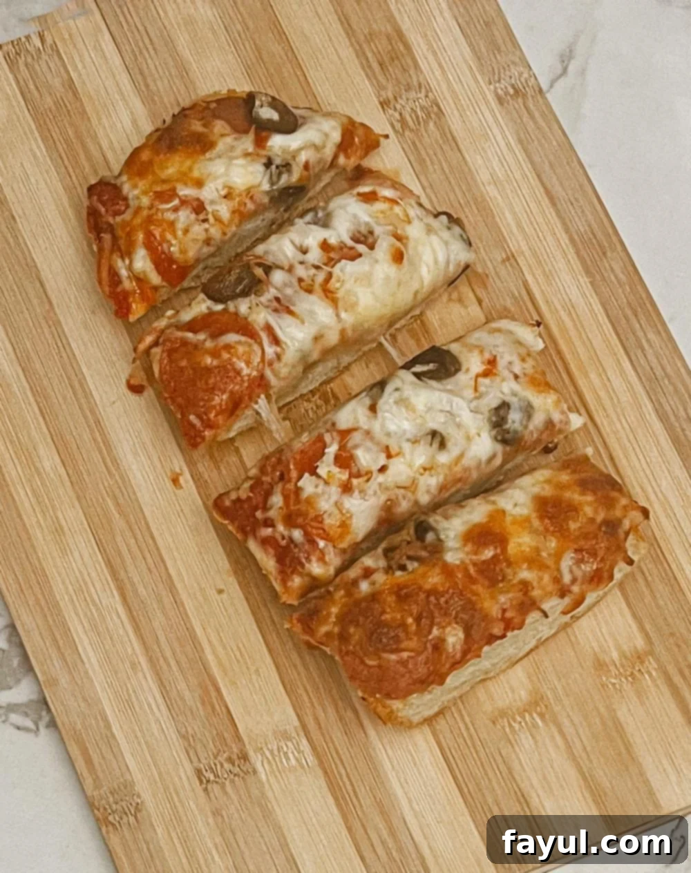 Homemade French Bread Pizza, perfectly baked with melted cheese and toppings on a crispy baguette.