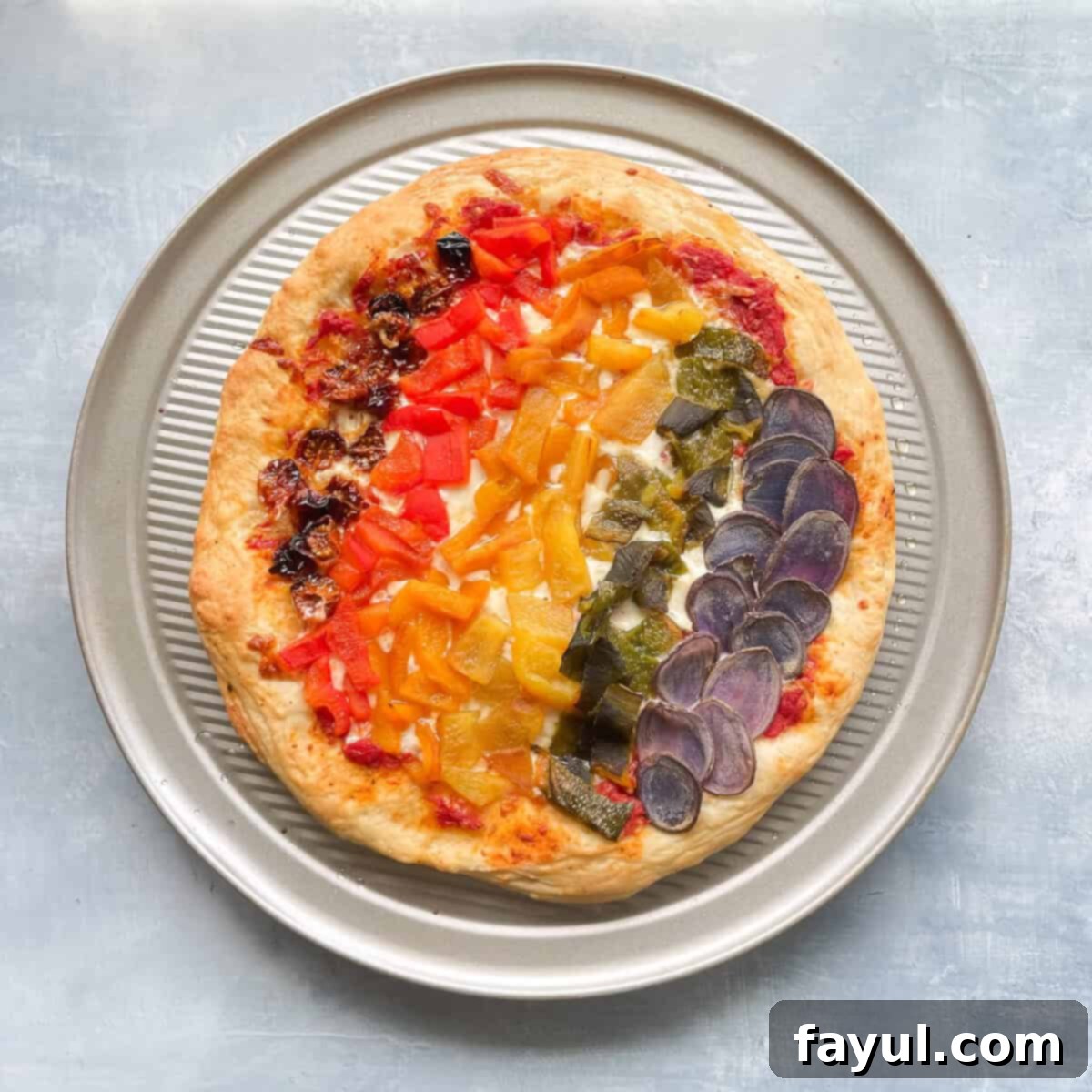 A colorful Rainbow Veggie Pizza, loaded with various vibrant vegetables arranged in an eye-catching pattern.