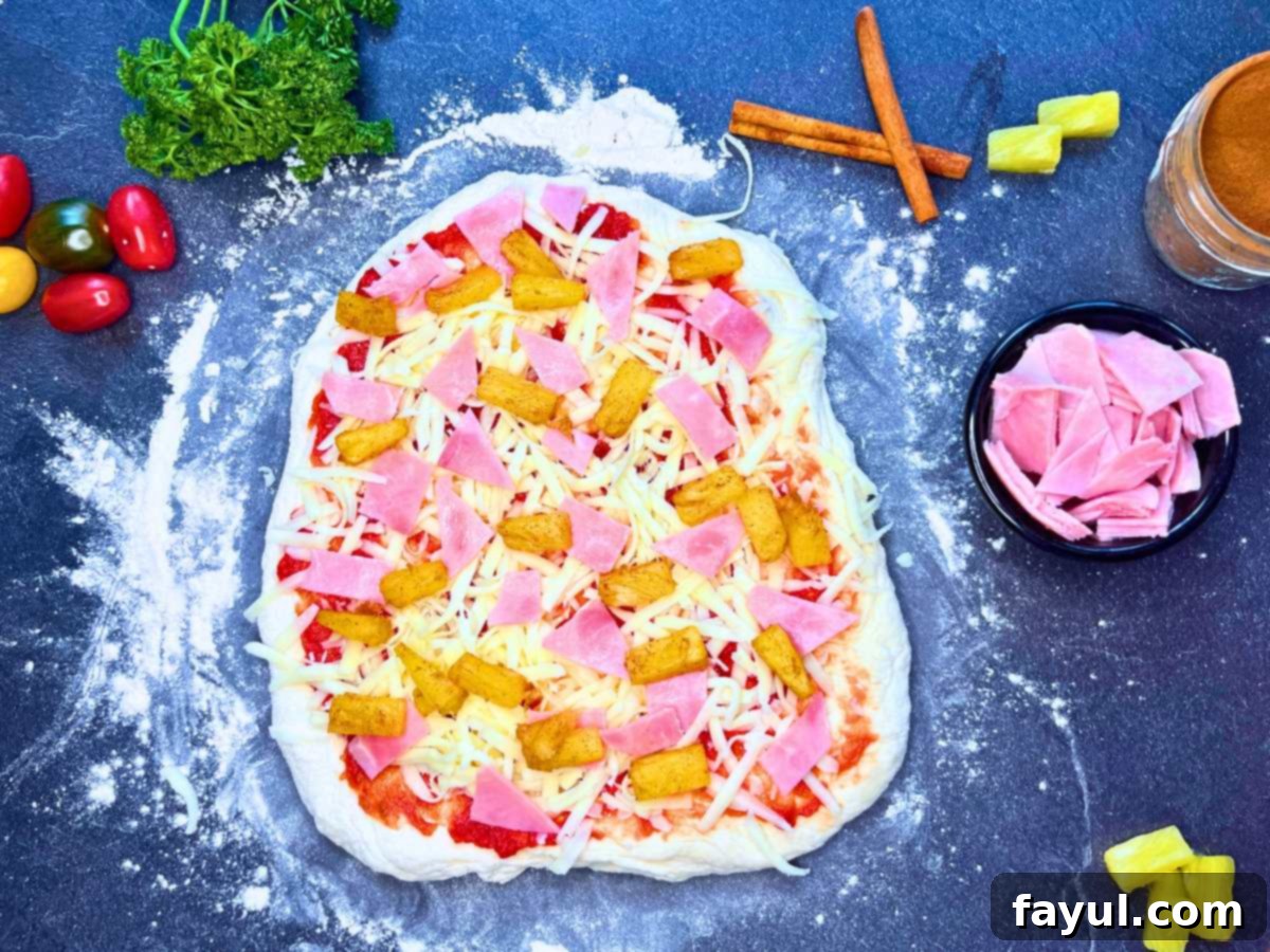 Homemade Hawaiian Pizza with caramelized pineapples, savory sliced ham, and melted cheese on a soft, chewy crust.