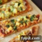 Close up shot of multiple slices of curry pizza arranged on a wooden cutting board.