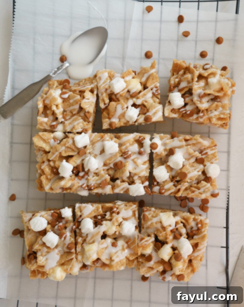 The Cinnamon Toast Crunch cereal and melted marshmallow mixture being gently folded in a large bowl.