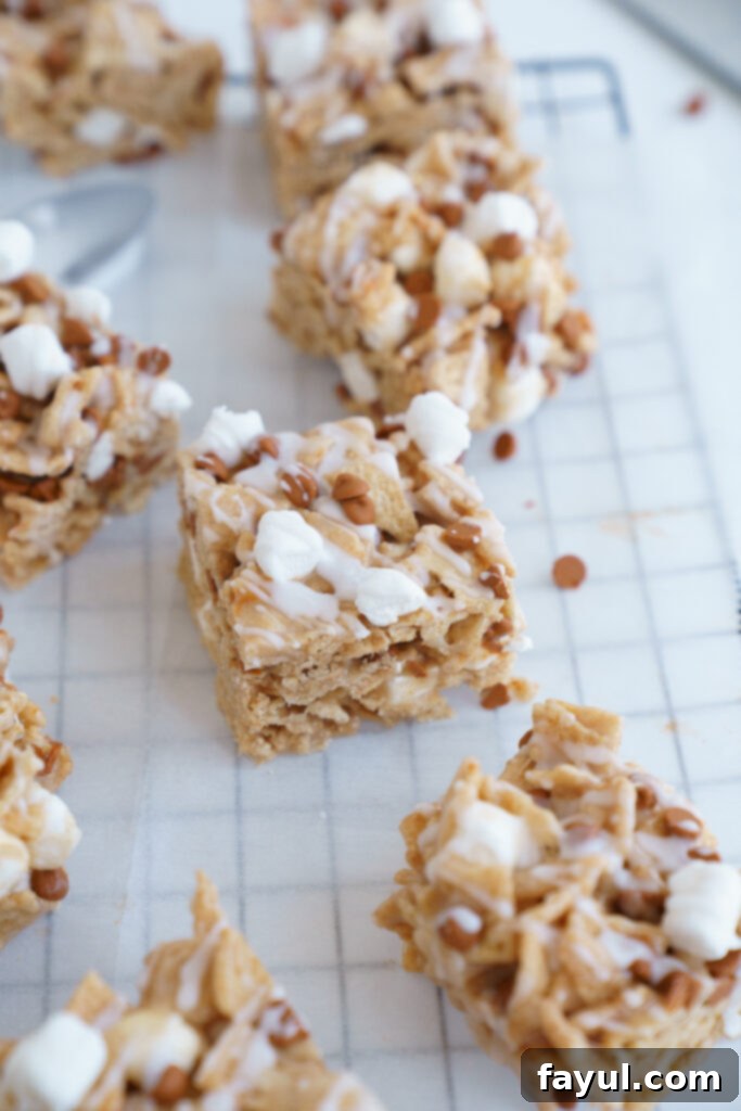 A close-up of a Cinnamon Toast Crunch Cereal Bar, showing the crispy cereal, gooey marshmallow, and cinnamon chips, with a slight blur in the background.