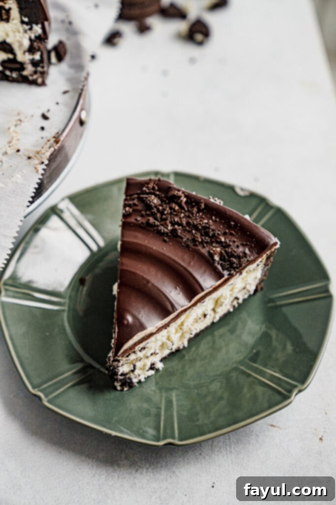 A slice of Oreo cheesecake, perfectly cut with a spoon nearby