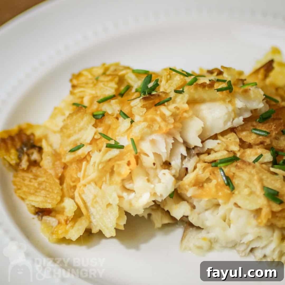 Close up shot of potato crusted cod on a white plate garnished with fresh herbs, ready to be served.