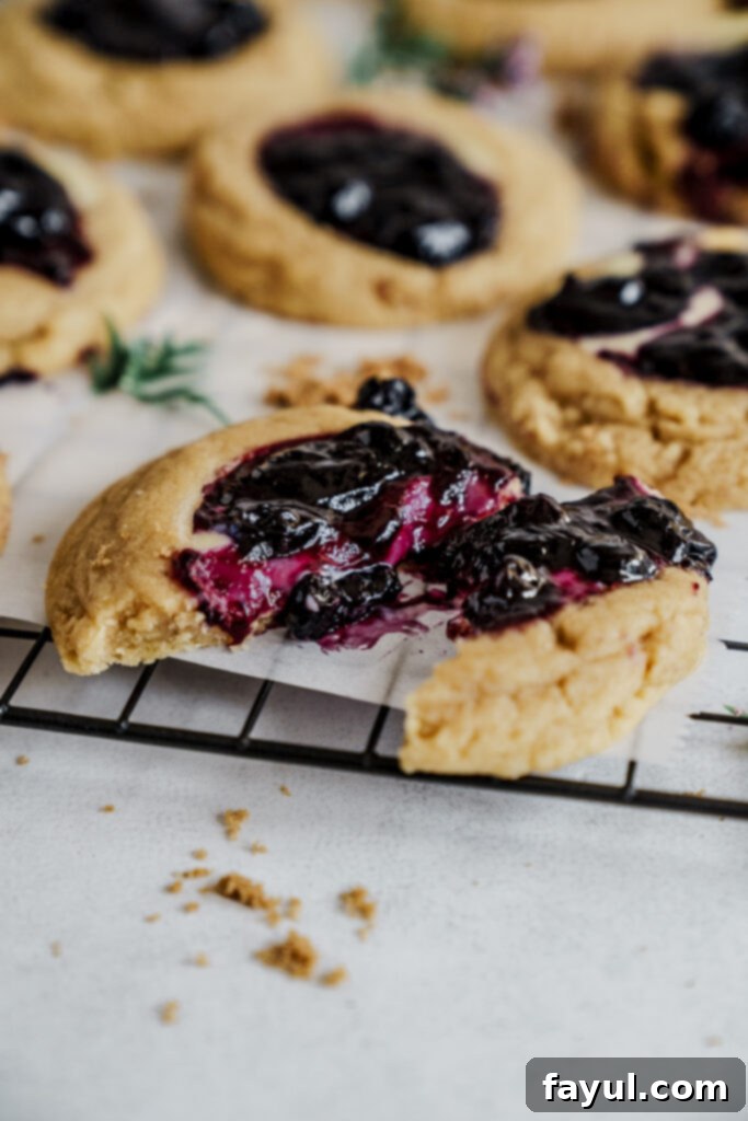 Close-up of a blueberry cheesecake cookie showing its creamy filling and compote
