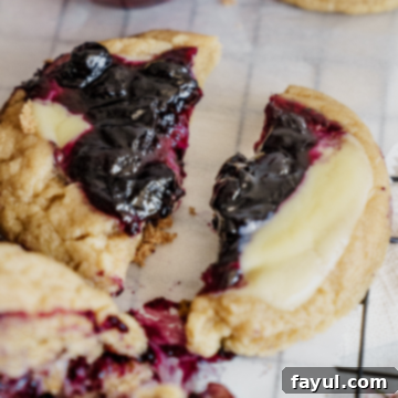 A top-down view of a single Blueberry Cheesecake Cookie, showcasing the filling and perfect bake.