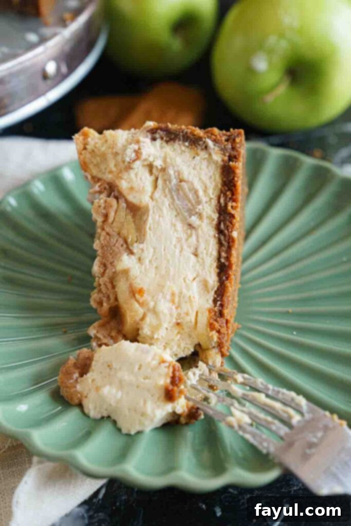 Ingredients for Apple Crisp Cheesecake laid out, including apples, Biscoff cookies, cream cheese, and spices