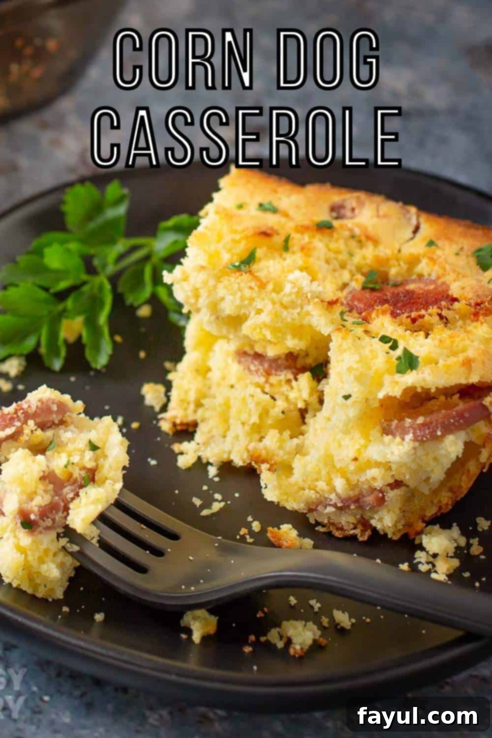 Side shot of a slice of casserole garnished with herbs on a black plate with a black fork holding a piece of casserole on the side.