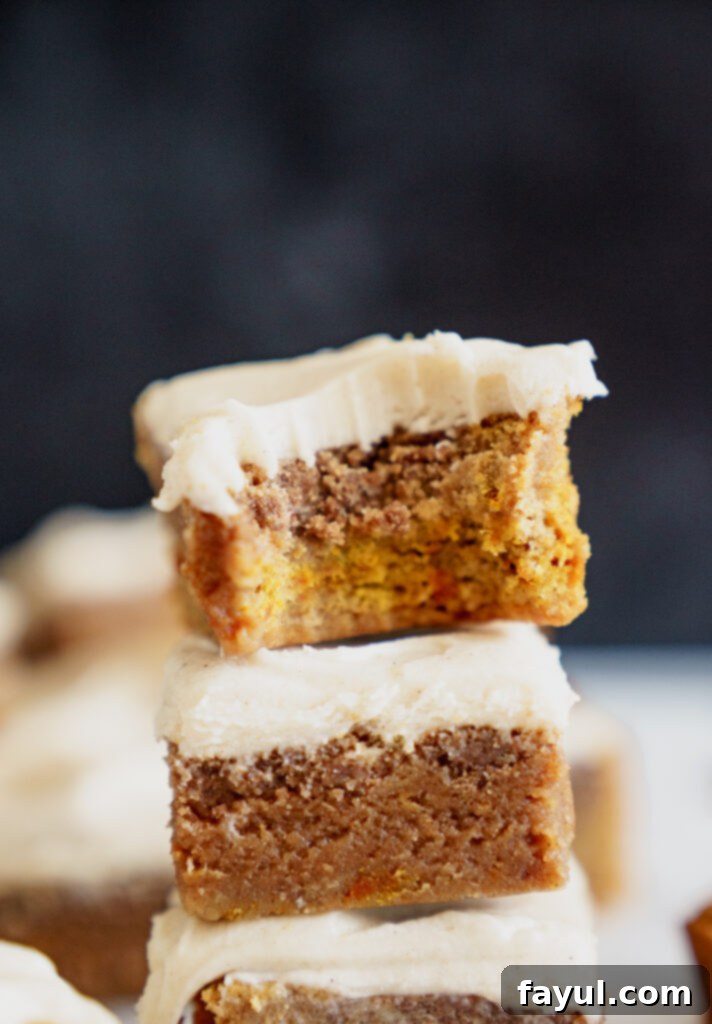 A tray of pumpkin blondies with creamy frosting ready to be served