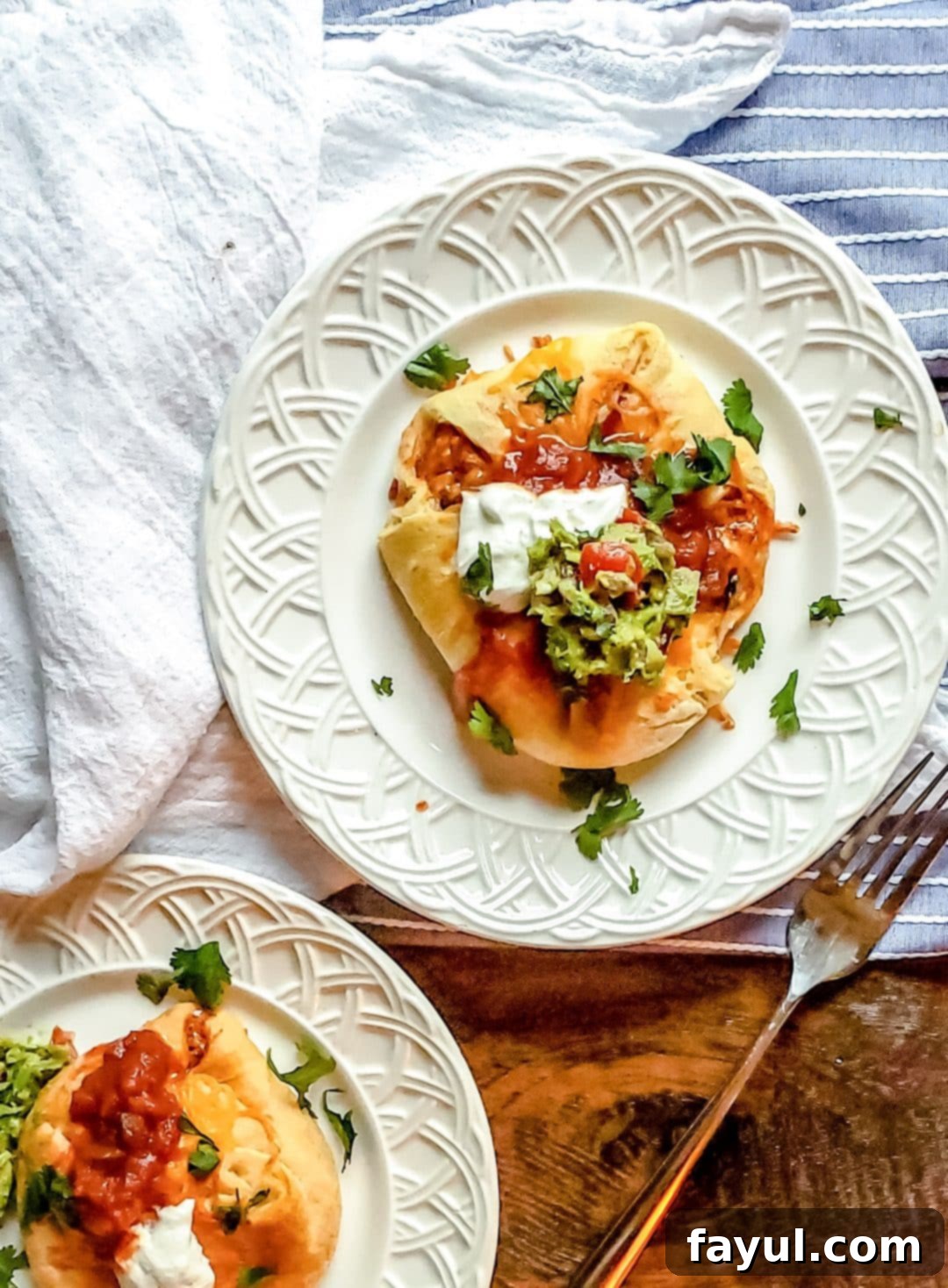 Close-up of a golden-brown chicken enchilada puff topped with melted cheese.