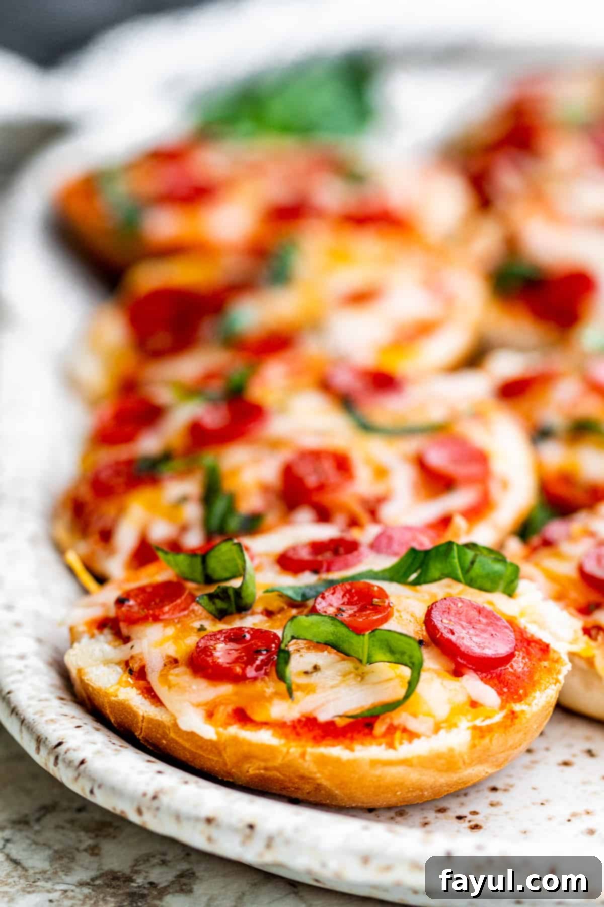 The Best Homemade Air Fryer Bagel Bites 2 Strait on shot of pizza bagels on white serving tray.