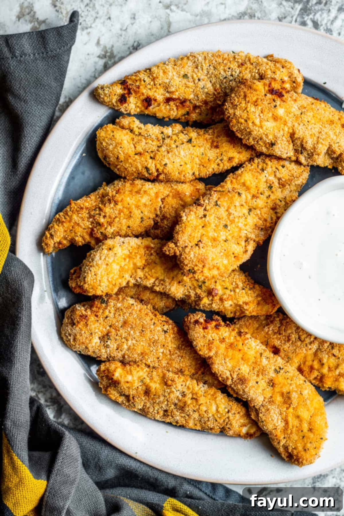 Overhead shot of crispy chicken tenders on a plate, ready to be served, highlighting their golden perfection.