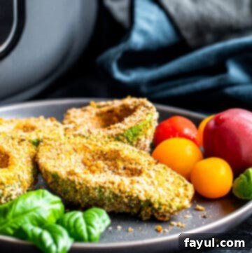 Angle shot of avocado on plate with tomatoes.