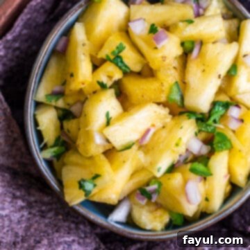 Sweet Heat Pineapple Jalapeno Salsa 7 Overhead shot of pineapple salsa in blue bowl with chips around it.