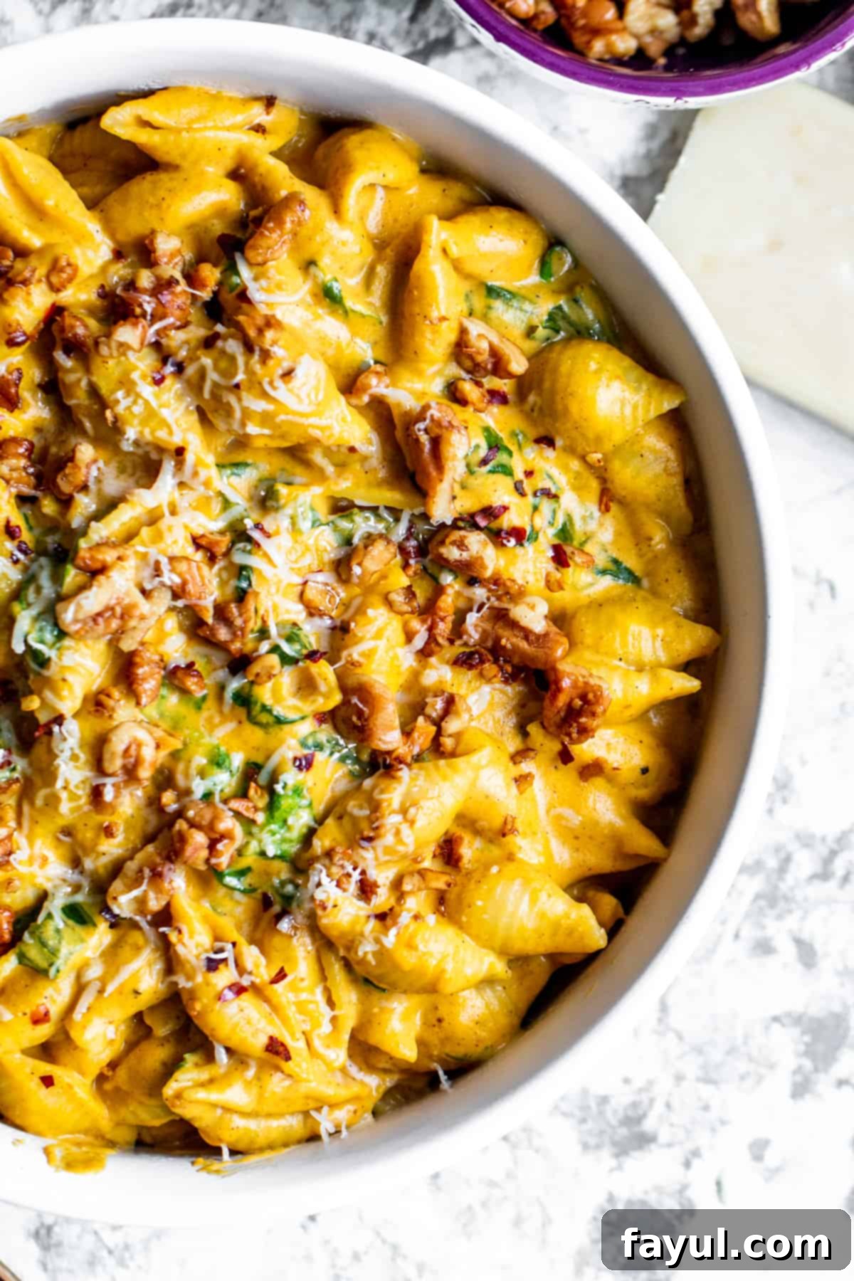 Velvety One-Pan Pumpkin Pasta 28 Overhead shot of creamy pumpkin pasta in a large white bowl on a white counter.