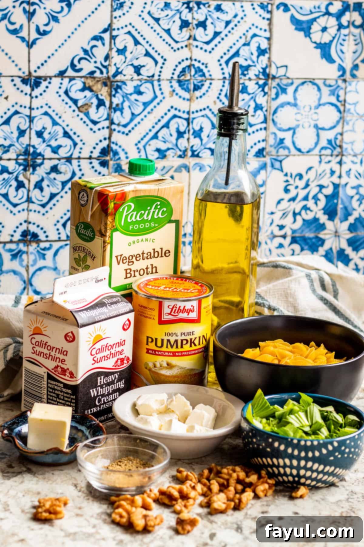 Velvety One-Pan Pumpkin Pasta 3 Recipe ingredients laid out on white counter in bowls and containers.
