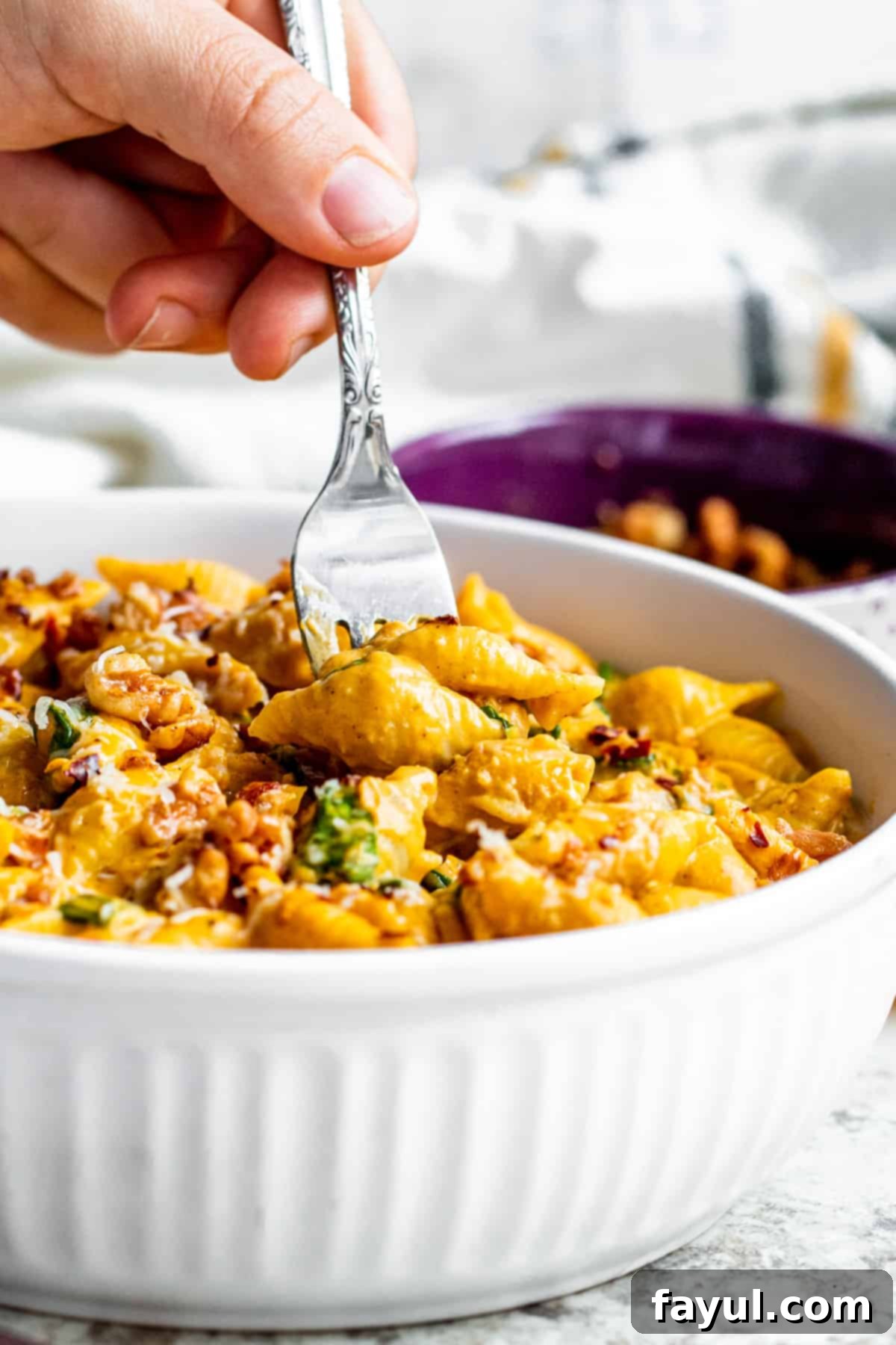 Velvety One-Pan Pumpkin Pasta 7 Silver fork getting pasta out of a white bowl.