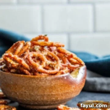 Simple Garlic Parmesan Pretzels 8 A bowl filled with crispy garlic parmesan pretzels, with some artfully fallen onto the table, highlighting their inviting texture.