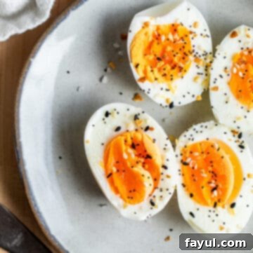 Overhead shot of peeled and sliced boiled eggs on gray plate.