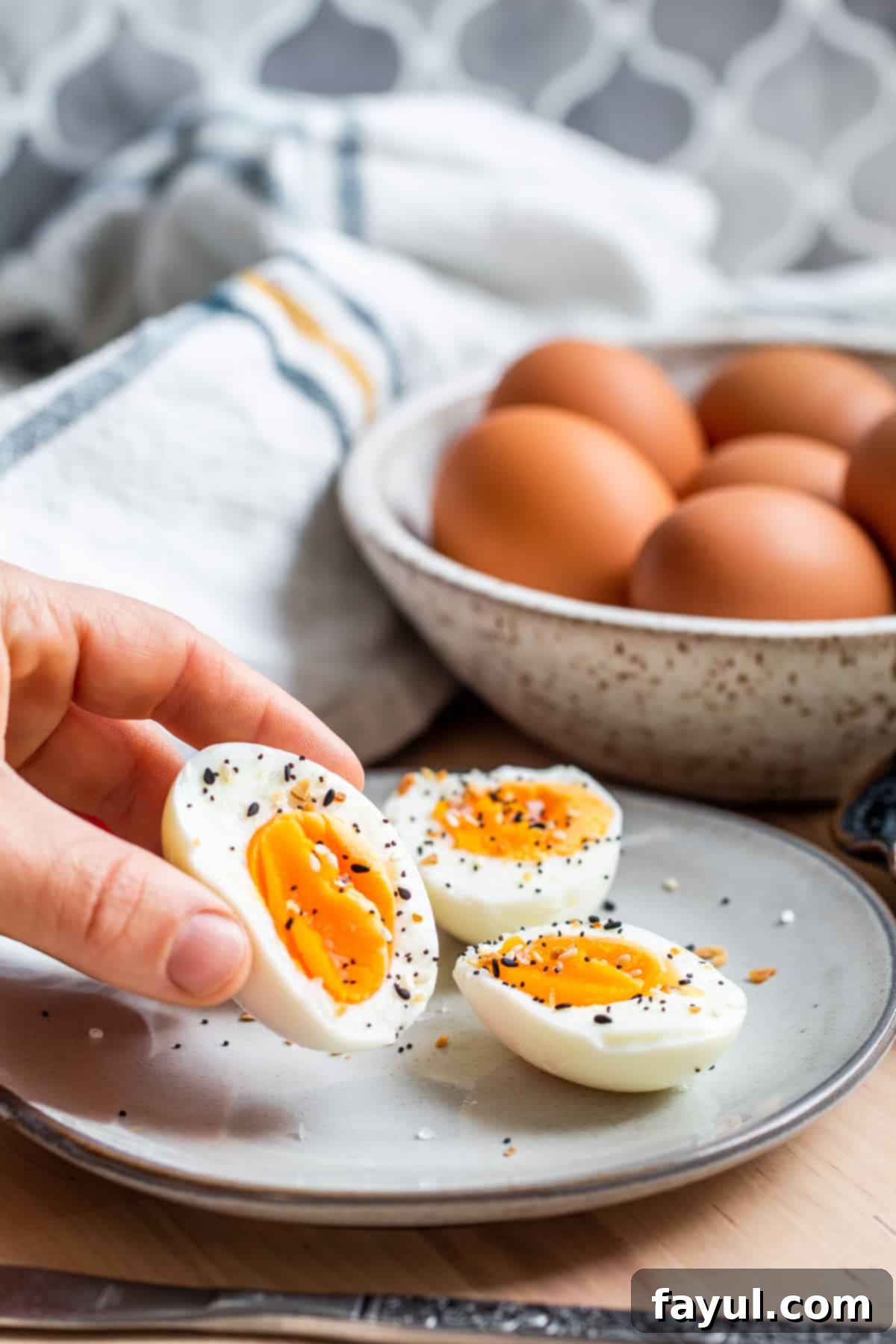 Hand picking up one egg from plate.