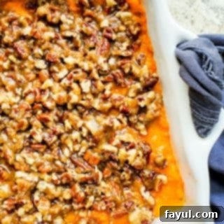 Overhead shot of sweet potato casserole in a white baking dish on a white counter.