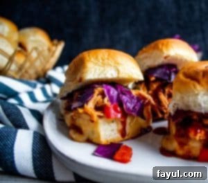 Delicious BBQ Chicken Sliders on a white plate with a striped towel on the side, ready to be served.