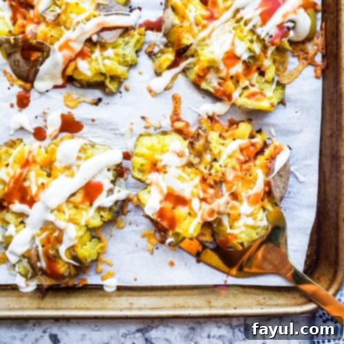 These Crispy Smashed Potatoes with Cheesy Buffalo Sauce is the perfect side dish recipe to pair with any family dinner. Boiled then baked in the oven these will become your favorite! #potatoes #food #sidedish