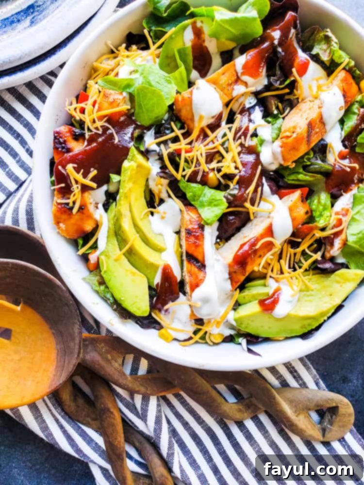 Smoky BBQ Chicken Salad with Creamy Buttermilk Ranch 6 Overhead shot of the BBQ Chicken Salad in a white bowl, with wooden spoons resting on the side, inviting you to dig in and enjoy the fresh ingredients.