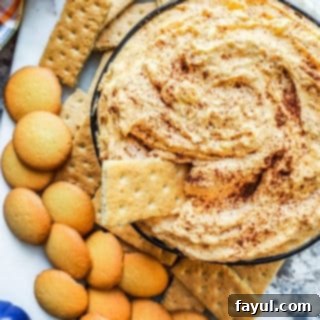 Overhead shot of pumpkin dip in a black bowl on a white counter, ready to be served.