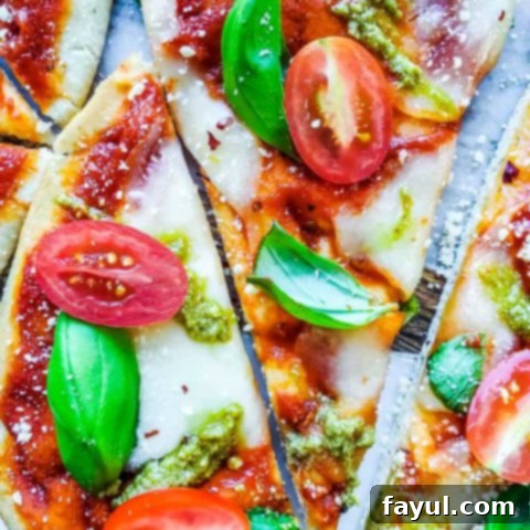 Quick and easy Margherita naan pizza with fresh basil and a pesto drizzle, perfect for a fast family pizza night.