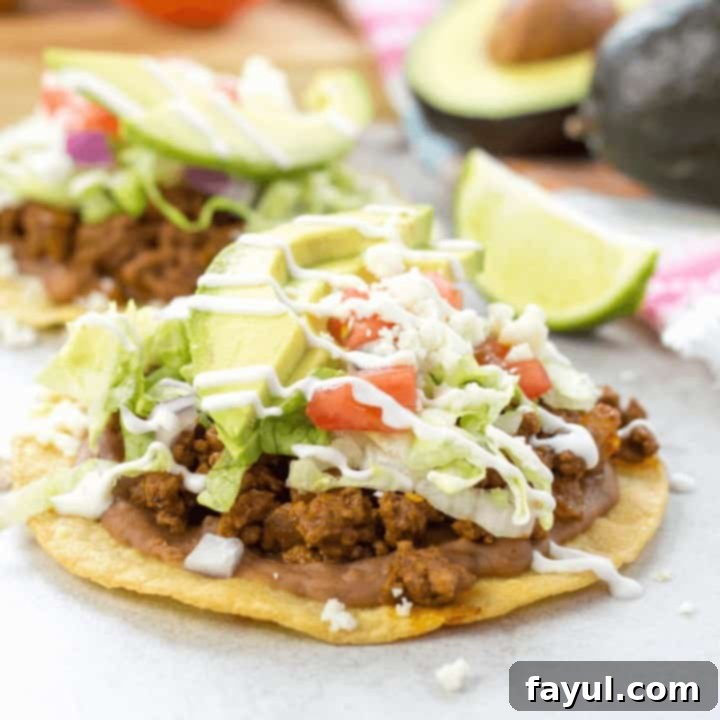 Crispy ground beef tostadas topped with refried beans, crema, and fresh toppings, a quick and spicy Mexican-inspired dinner.