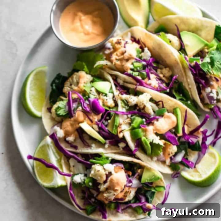 Crispy cauliflower tacos drizzled with spicy cashew sauce and topped with fresh cilantro, a healthy and flavorful meal.