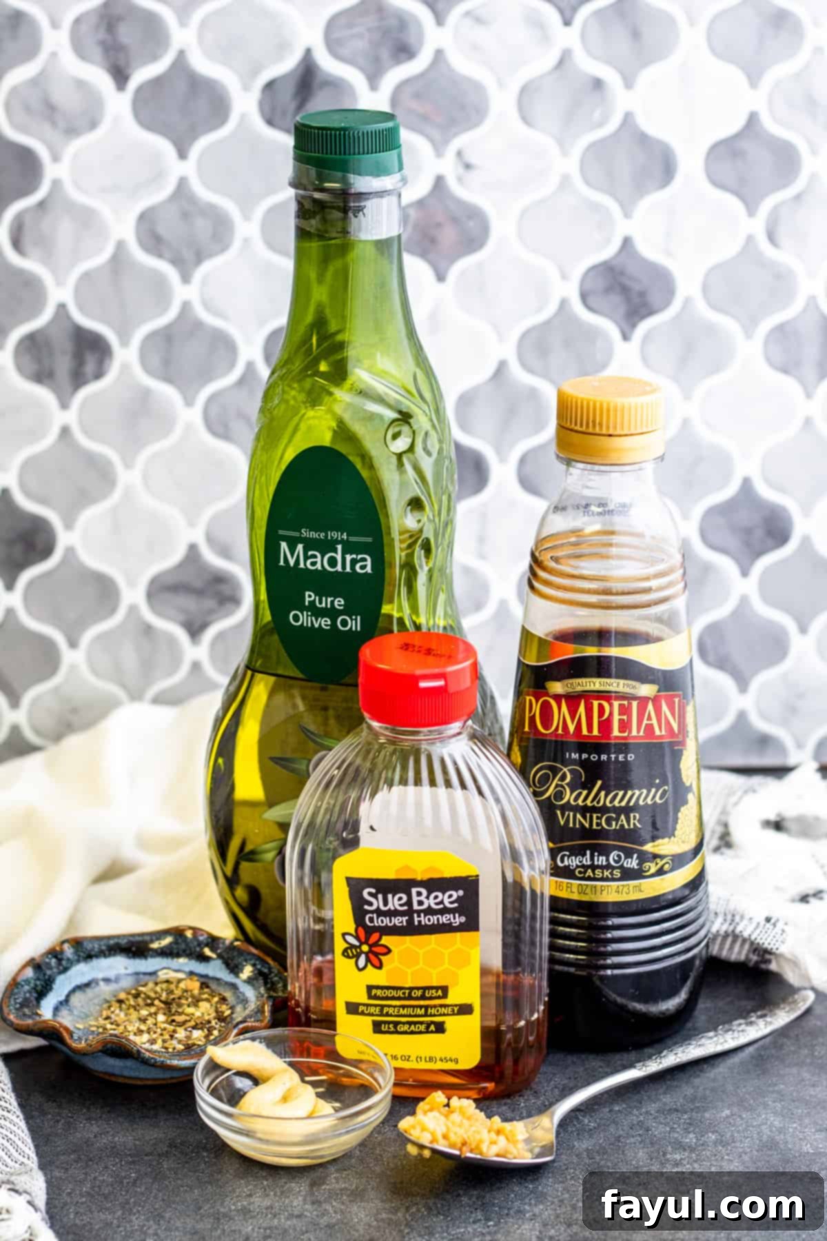 Artisan Balsamic Vinaigrette 2 Ingredients for dressing laid out on dark blue table.