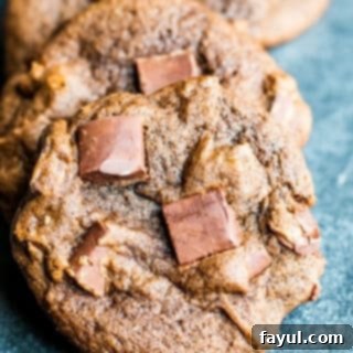 Irresistibly Chewy Double Chocolate Chip Delights 3 Close up shot of chocolate cookie in a line of other cookies on a blue counter.