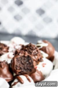 Oreo balls in a bowl with one with a bite out of it on a blue counter.