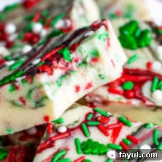 Festive Swirl Sugar Cookie Fudge 3 Close up of sugar cookie fudge with a bite out of it, showing the smooth texture and sprinkles.