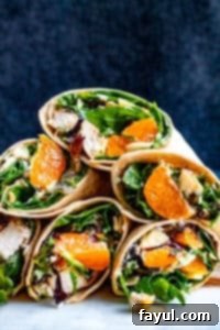 Stacks of chicken wraps on a white counter with blue background.