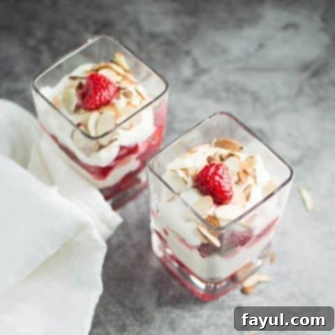 Elegant almond raspberry ricotta parfaits layered in clear glasses, featuring creamy ricotta, fresh raspberries, and crunchy almonds, ideal for a quick romantic dessert for two.