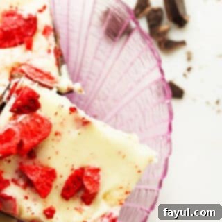 Addicting strawberry and chocolate bark, featuring a marbled pattern of pink and dark chocolate, studded with dried strawberries, perfect as a homemade holiday gift or treat.