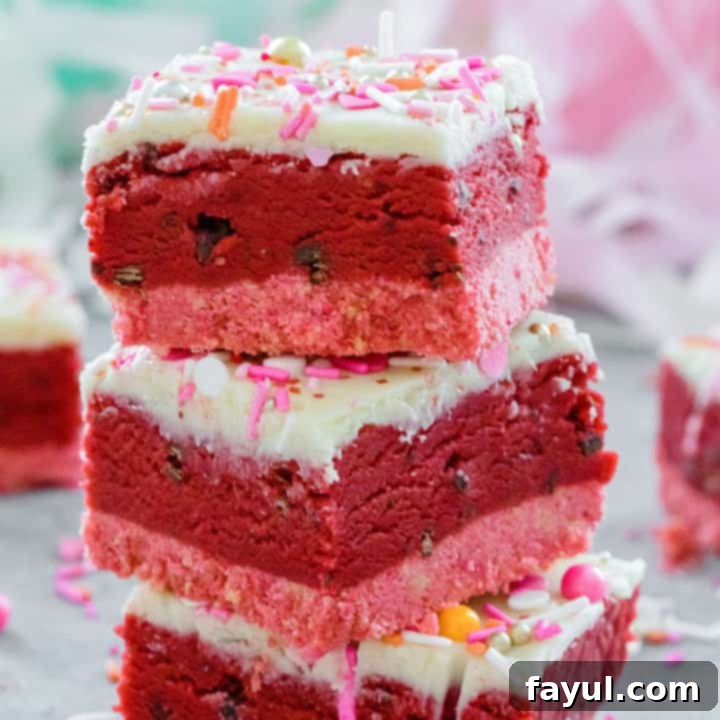 No-bake Red Velvet Cookie Dough Bars, showcasing layers of pink crust, chocolate chip red velvet cookie dough, white chocolate ganache, and sprinkles, perfect for Valentine's Day.