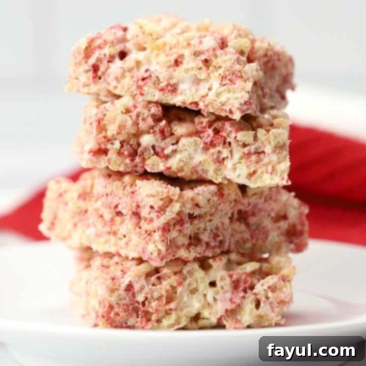 Pink and gooey Strawberry Rice Krispies Treats, a fun and fruity twist on the classic, adorned with sprinkles, perfect for a kids' Valentine's Day treat.