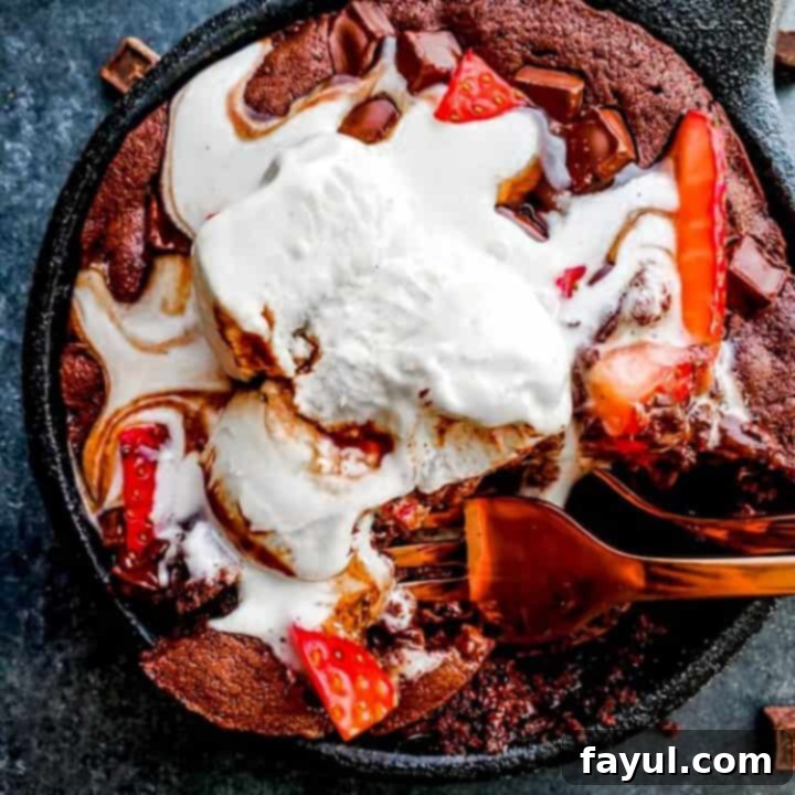 Decadent skillet brownie sundae, freshly baked in a cast-iron skillet and topped with ice cream, perfect for a romantic dessert for two.