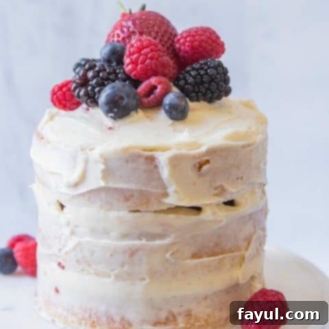 Charming mini vanilla cake topped with fresh red berries, perfect for a personalized Valentine's Day treat.