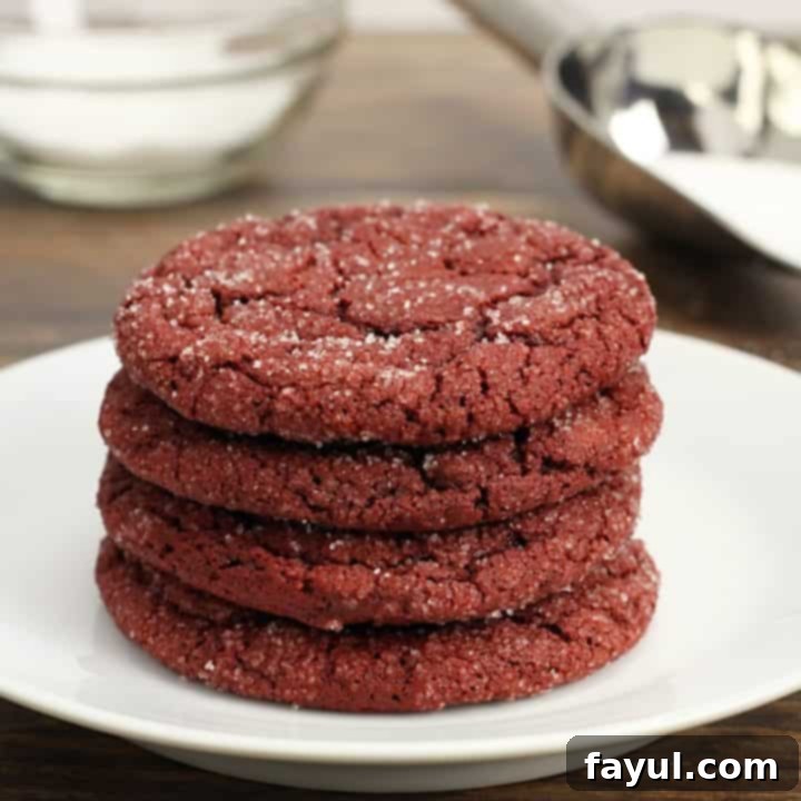 Soft and chewy Red Velvet Sugar Cookies with a deep red color and delicate cocoa flavor, frosted and adorned with sprinkles, perfect for Valentine's Day.