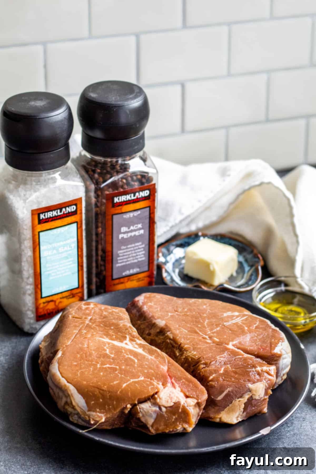 Steak and ingredients laid out on counter top on blacks and bowls.