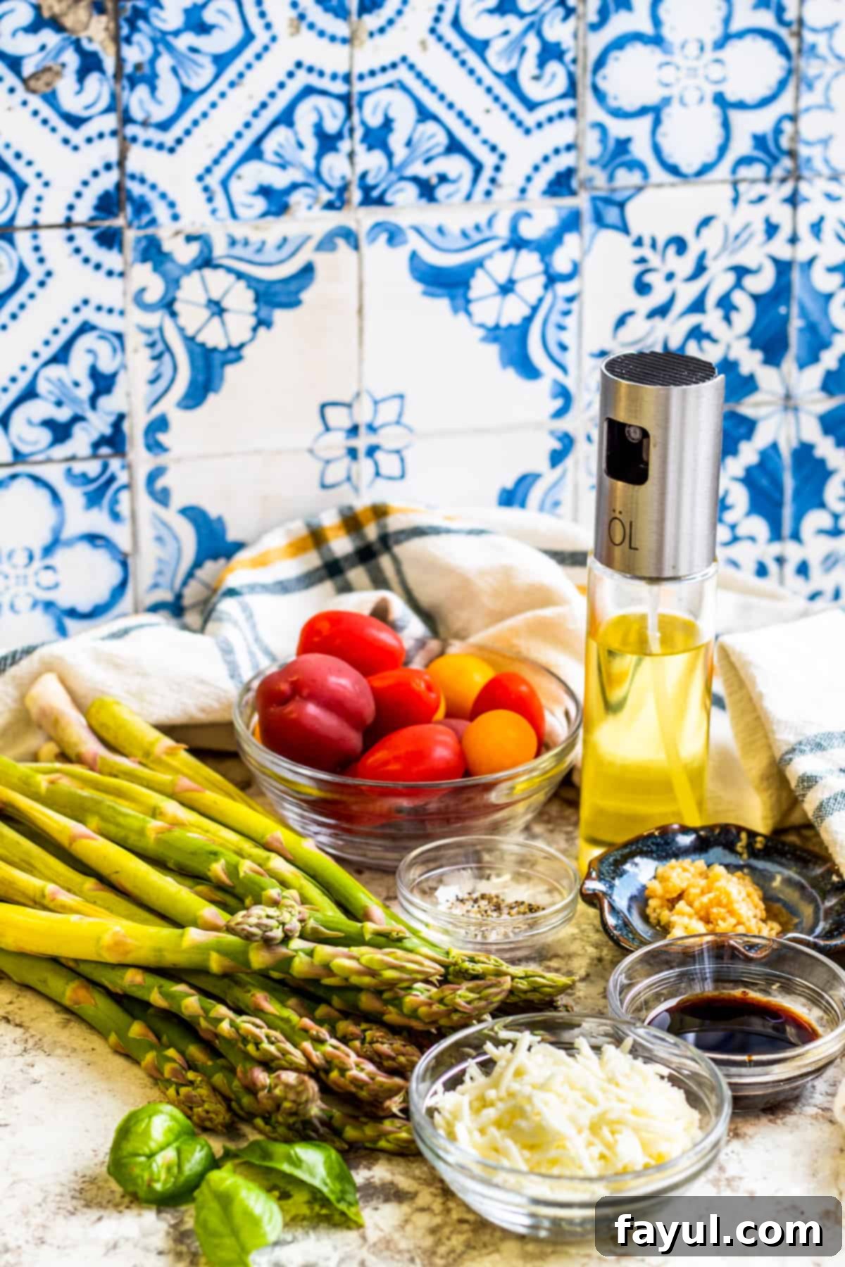 Roasted Balsamic Asparagus with Burst Cherry Tomatoes 2 Asparagus recipe ingredients laid out on table in small glass bowls, including asparagus, cherry tomatoes, olive oil, and balsamic vinegar.