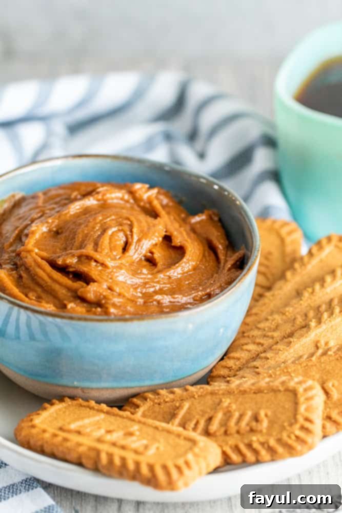 The 5-Minute Cookie Butter Hack 6 An inviting angle shot of a vibrant blue bowl filled with creamy cookie spread, with a few whole cookies scattered around the base.