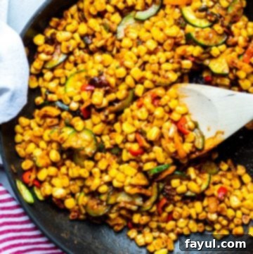 Warm corn salad in a black skillet.