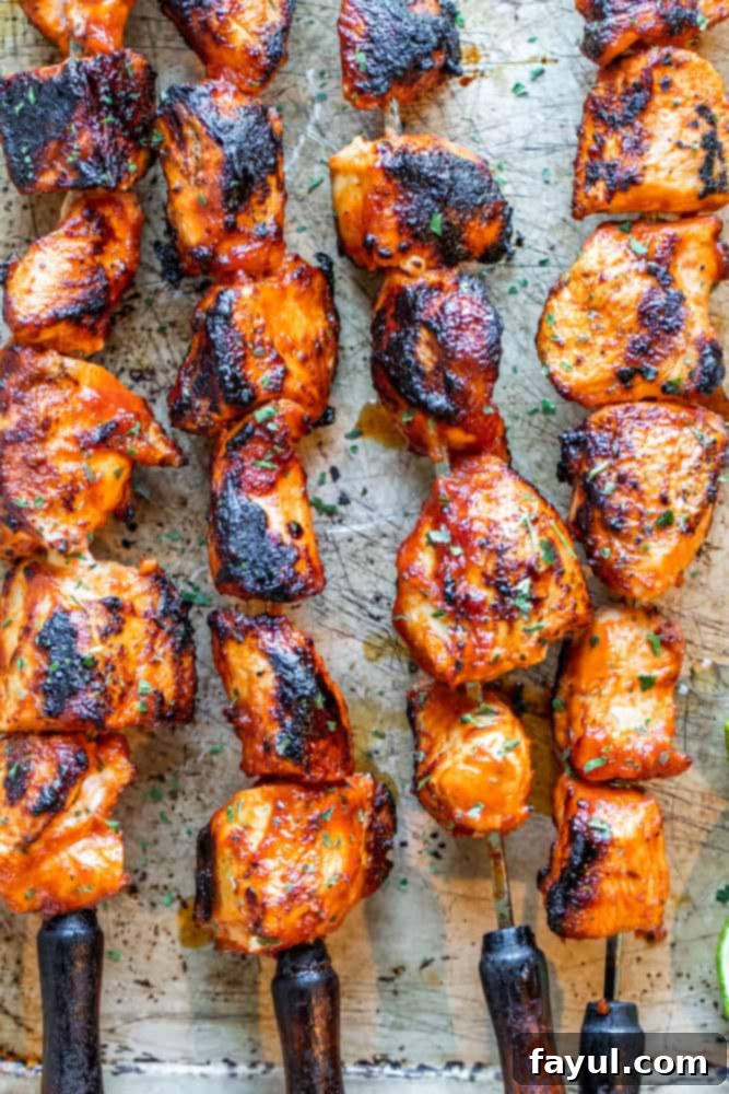 Chipotle Honey Glazed Chicken Skewers 2 Honey Chipotle Chicken Skewers on metal skewers on an old cookie sheet, ready for grilling.